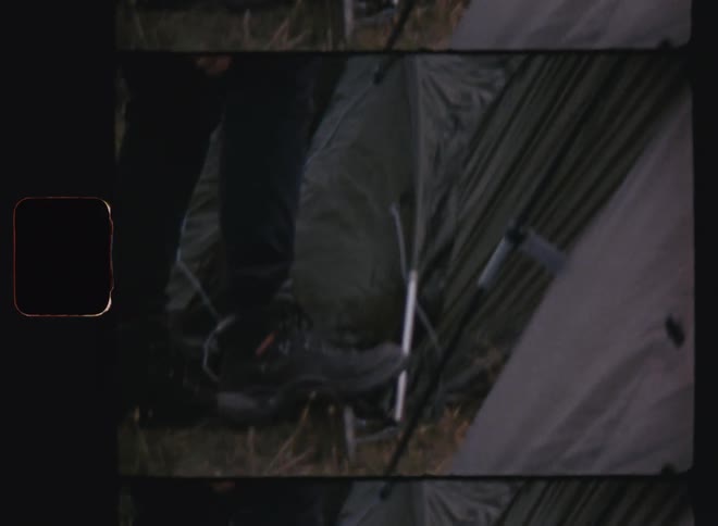 Man steps on tent stake while setting up camp on a windy day