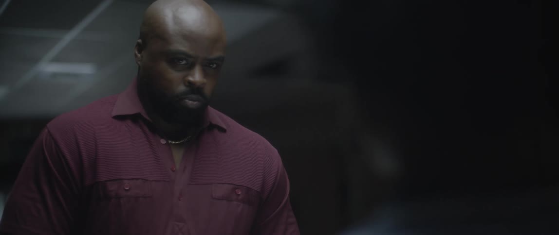 Man looking sternly at a boy in a dark room