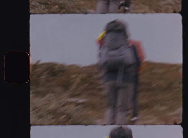 Three hikers move up rough sloping trail in single file