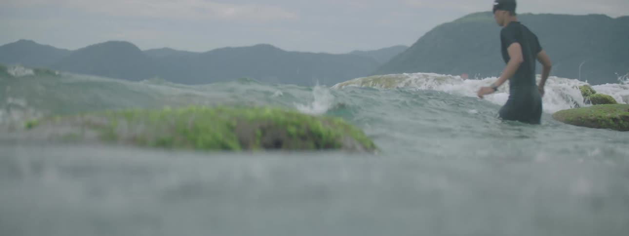 Man walking and swimming sequentially in the sea