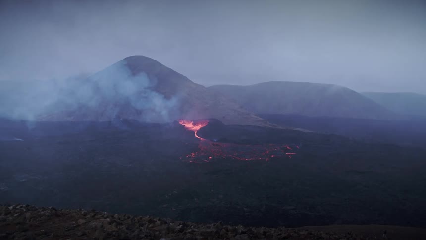 Lava flow from a volcanic eruption in the mountain as smokes cover the atmosphere