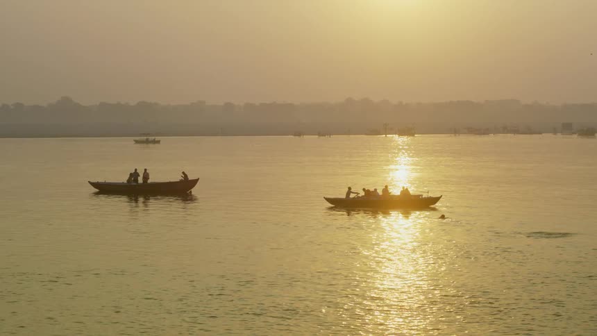 View of the sea with boats people and the reflection of the late afternoon sun