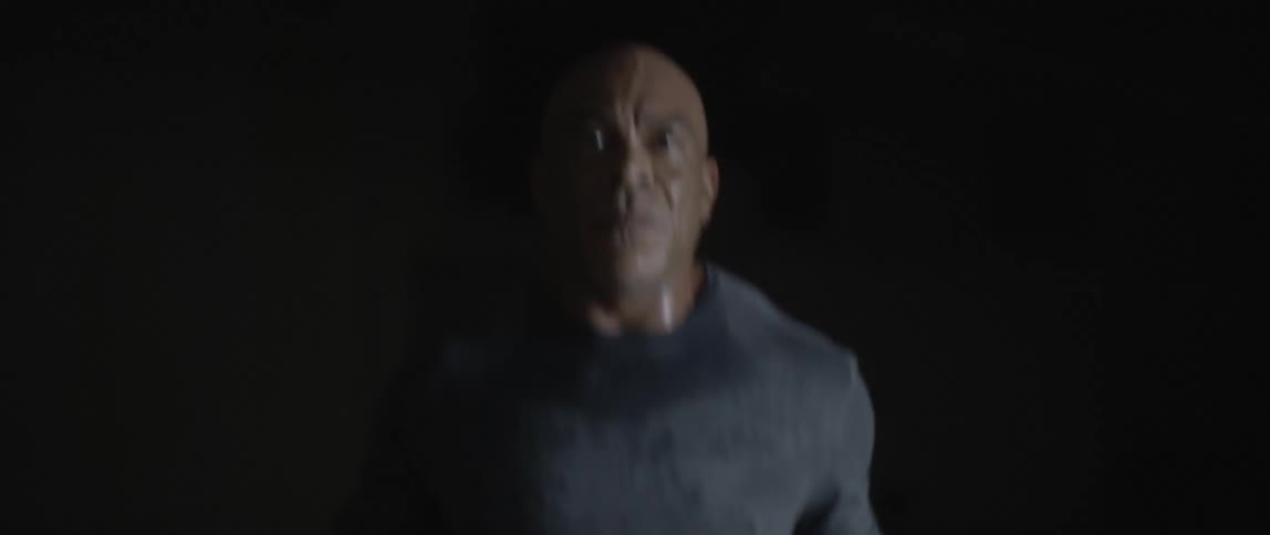 A muscular bald man concentrates while jumping rope as exercise