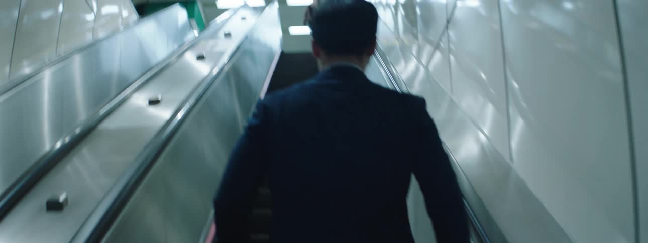 A man in a suit climbing a staircase