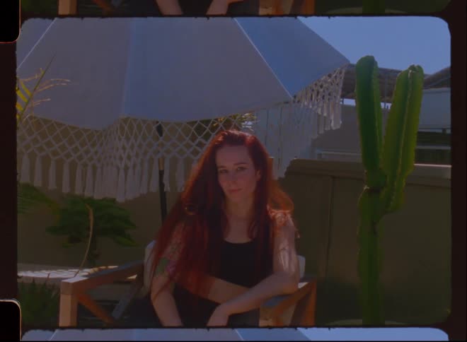Redhaired woman sitting in an outdoor setting