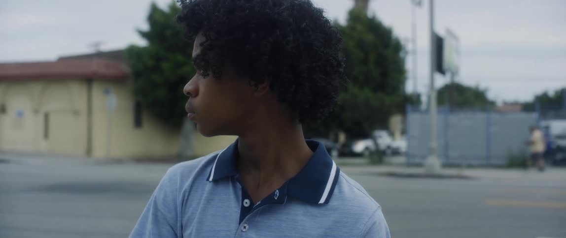 Teenager stands near road looking around