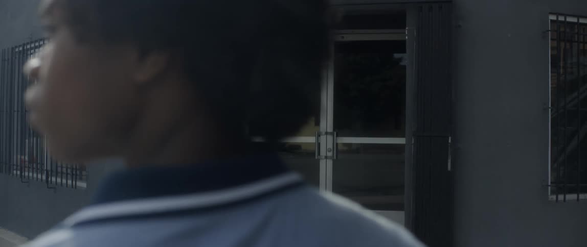 A clip of a teenager standing in front of a door