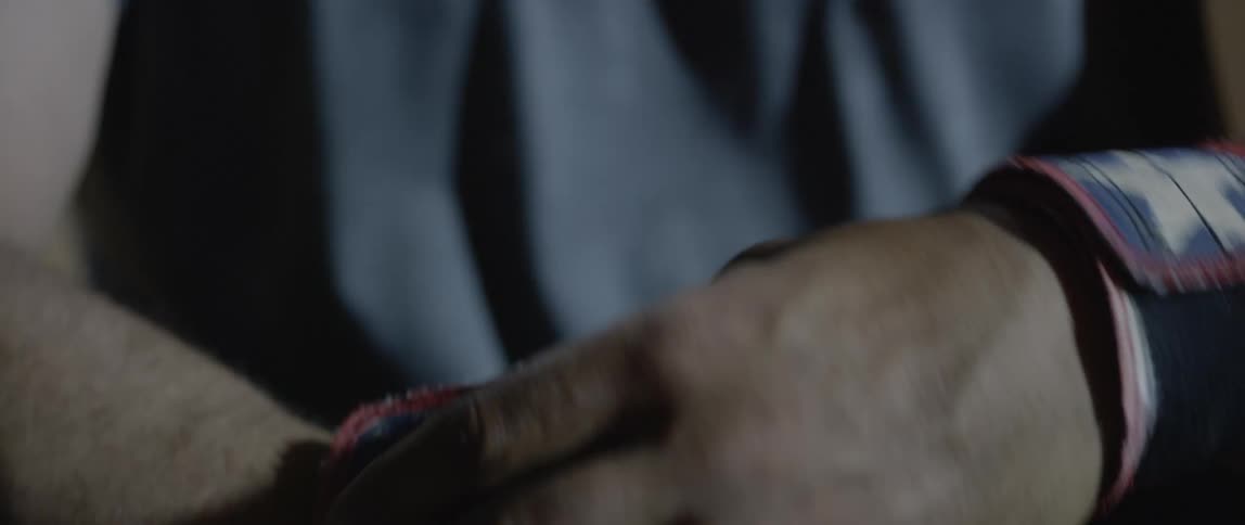 A man is wrapping wrist bands around his wrists