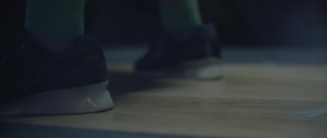 A person wearing tennis shoes does a small jump
