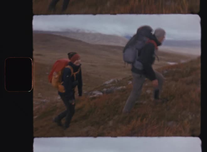 Man and woman climbing a mountain in a cold environment during the day