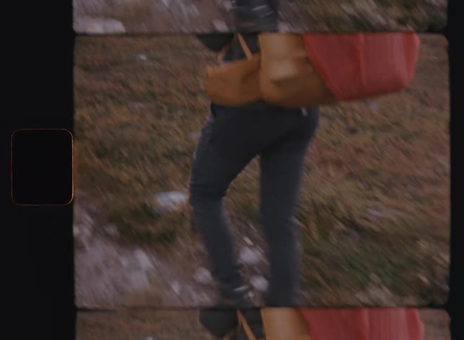 Backpacker carries bright backpack along narrow sloping trail