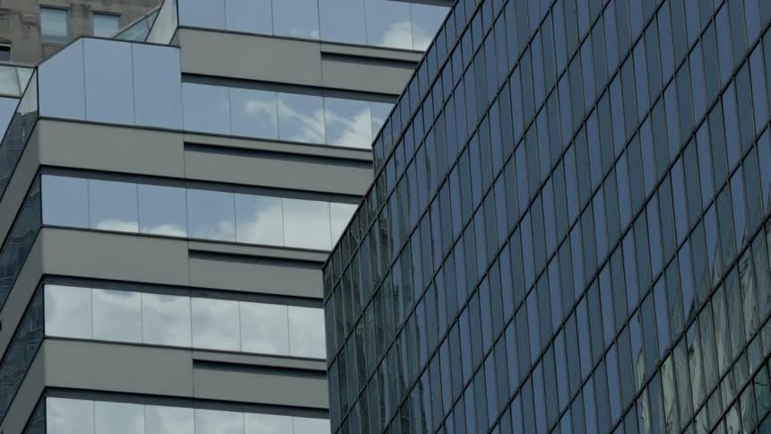 Clouds reflect off the windows of these buildings
