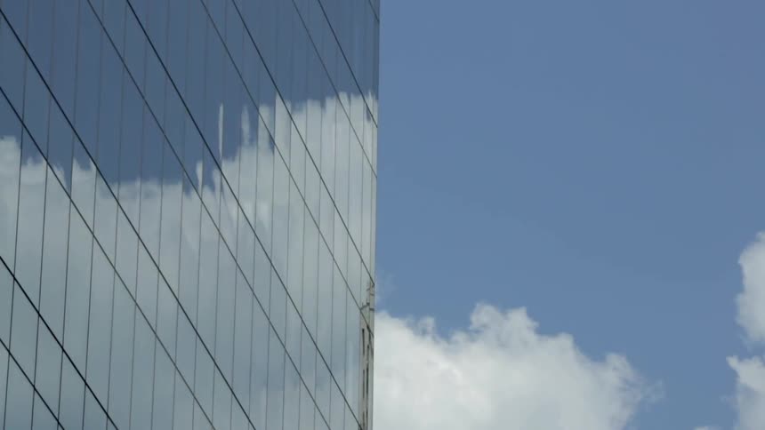 Clouds are passing this building with reflective windows