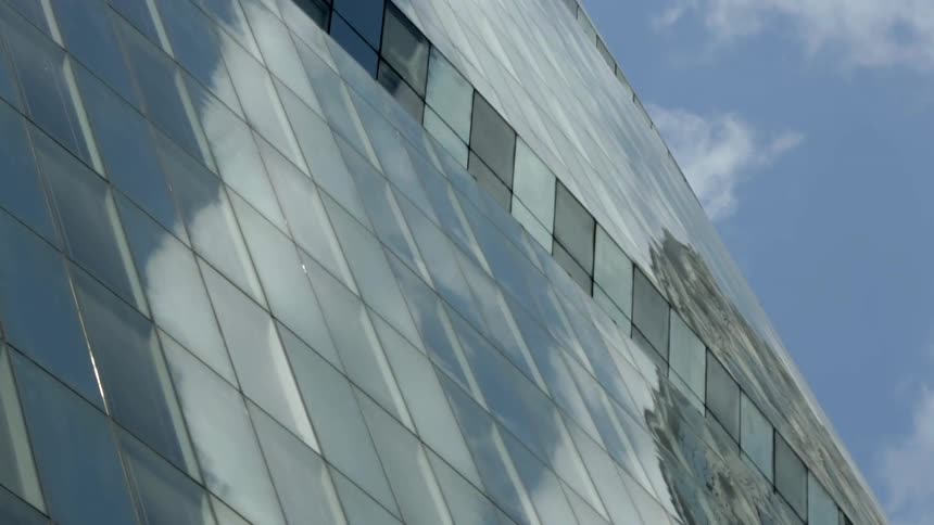 Time-lapse of clouds moving over a shiny building