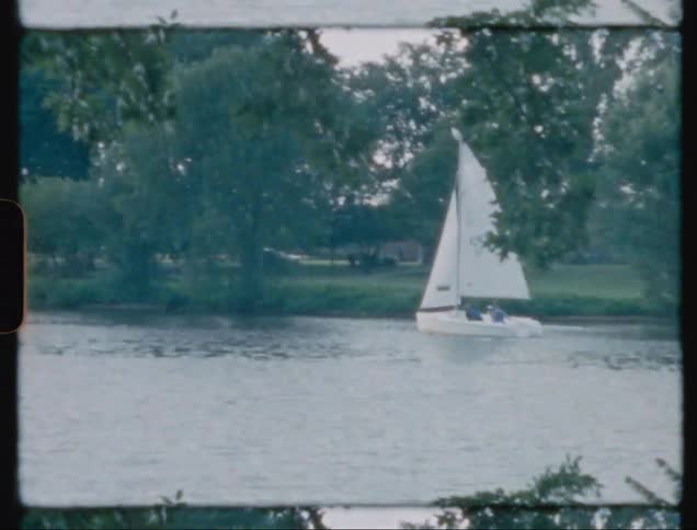 A sailboat is traveling down the river