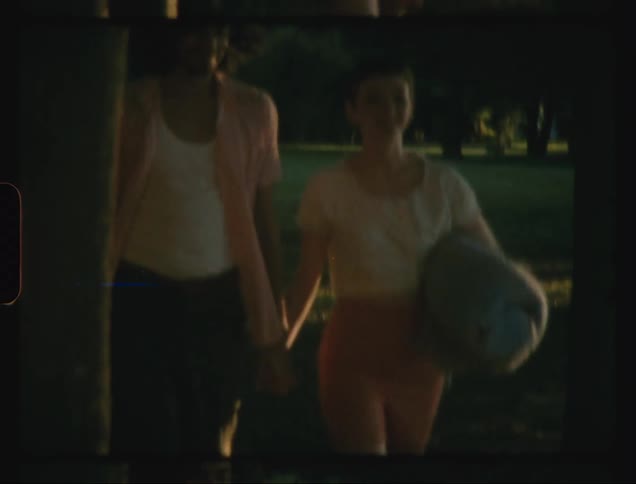 A young couple walking hand in hand in a park