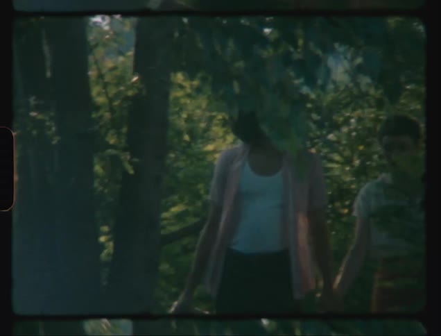 A couple walking hand in hand in the forest