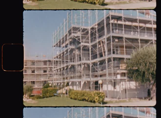 Scaffolding around a building in the city caught on vintage film