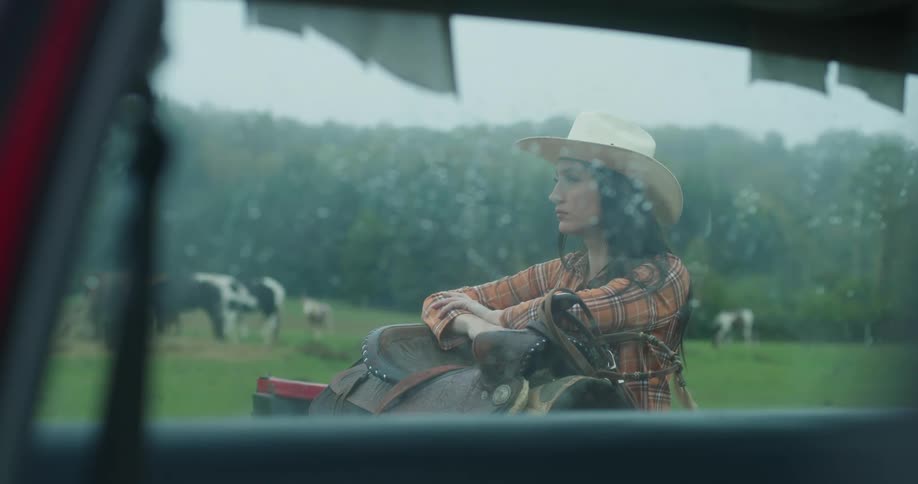 Cowgirl reclined over a saddle waiting in the countryside