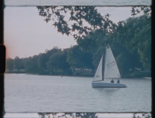 A small sail boat travels in the lake