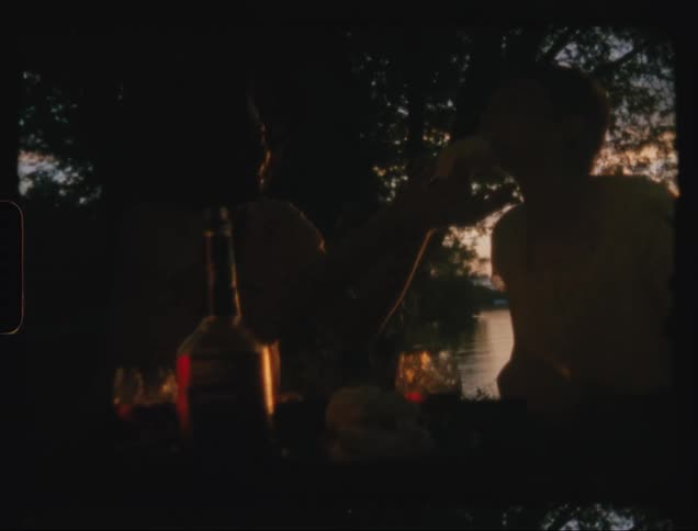 Two people are having a picnic by the lake