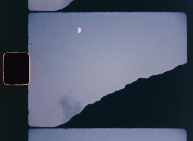 View of the dark of night with the silhouette of a mountain and a half moon