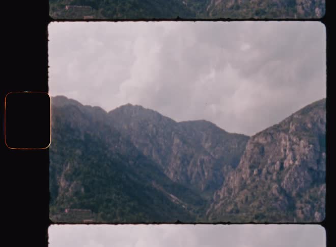 Light fog fills narrow valley between mountains under an overcast sky