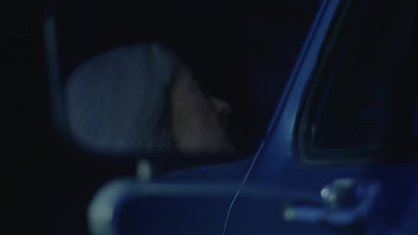 A woman shuts off the headlights on her vehicle