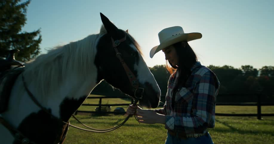 A woman and a horse on an outdoor ranch