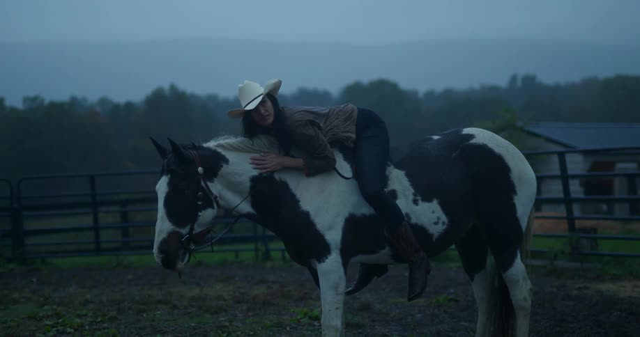 A woman hugging a horse on an outdoor ranch