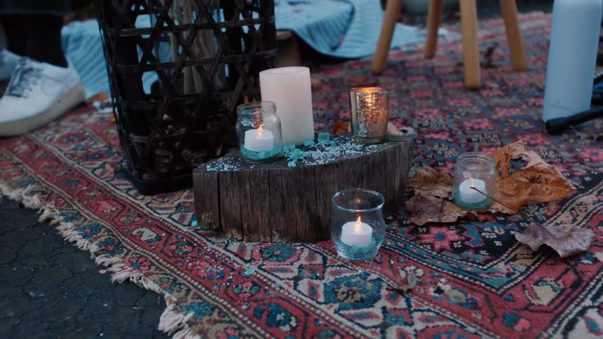 A picnic has candles on the blanket
