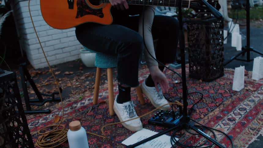 Woman plays the acoustic guitar outdoors