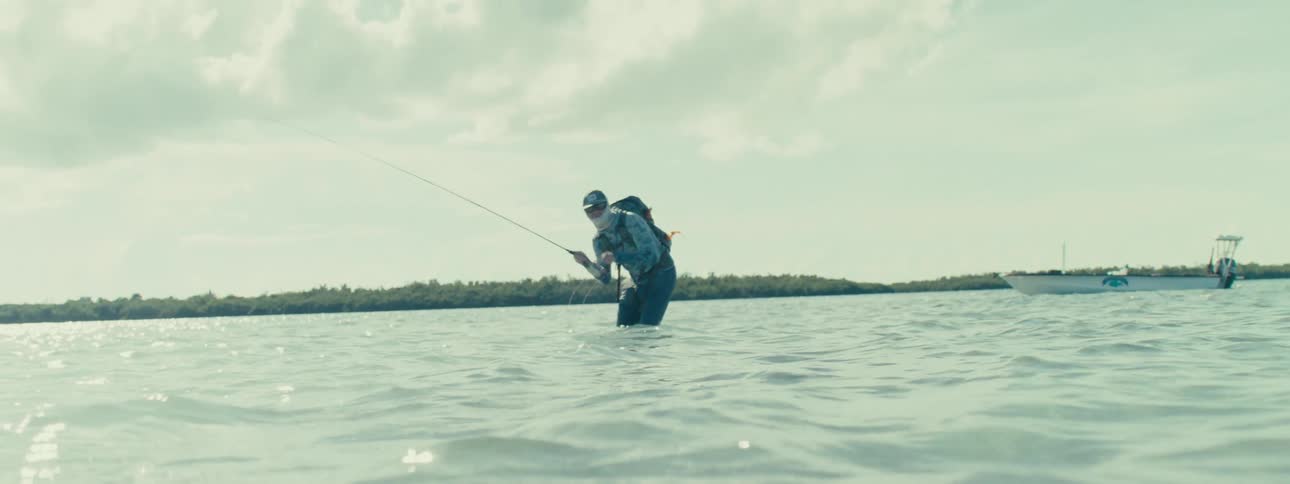 A man fishing at high tide during the day