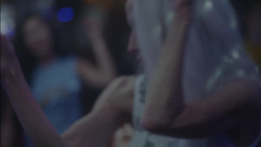 Older woman dancing and enjoying herself among others in a club