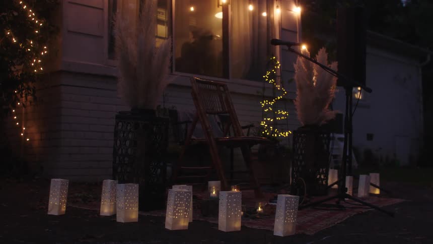 Night view of a backyard with a chair and a music microphone adorned with lights