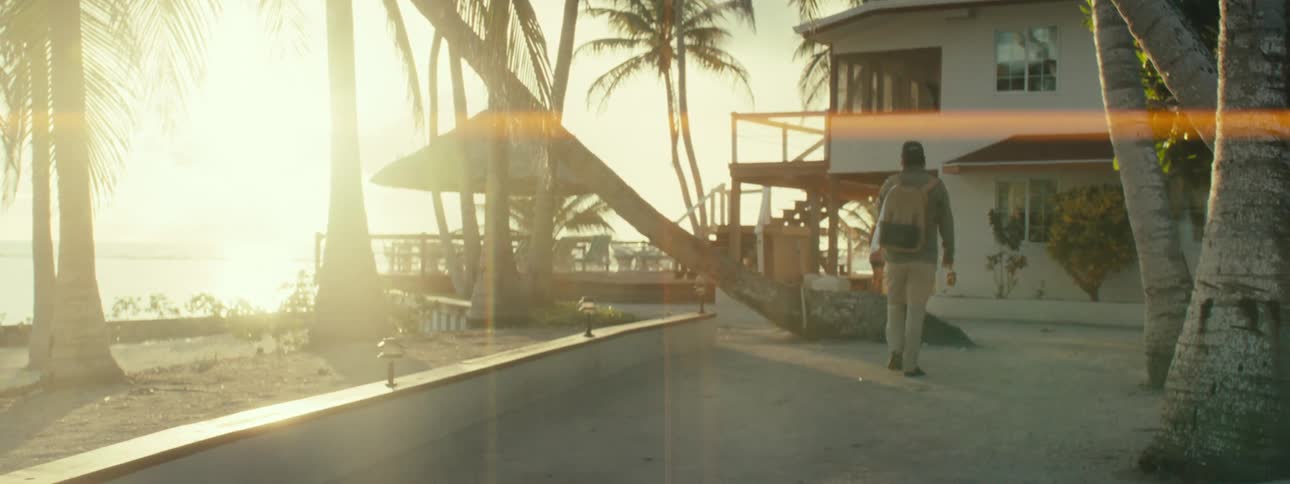 The man is walking towards the house and he turns around and looks behind him