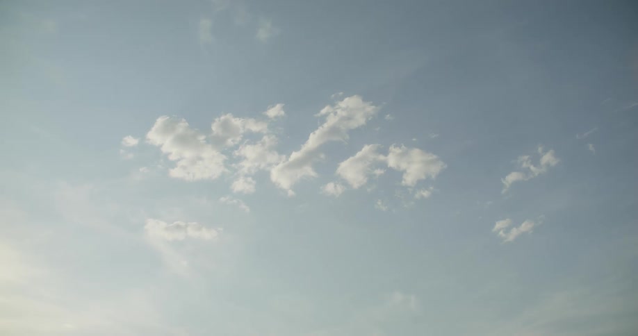 Small clouds are slowly moving in the sky during the daytime