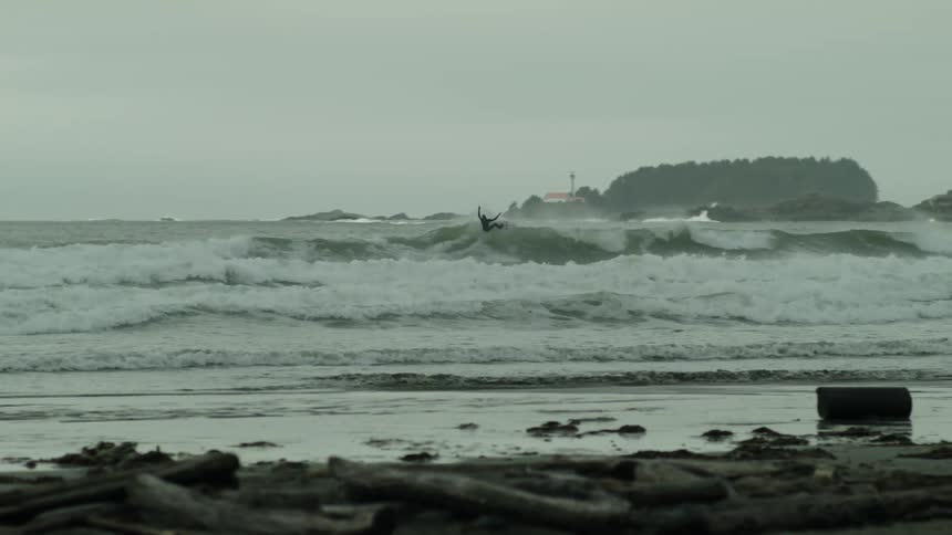A person surfing dangerous waves during the day dubbed