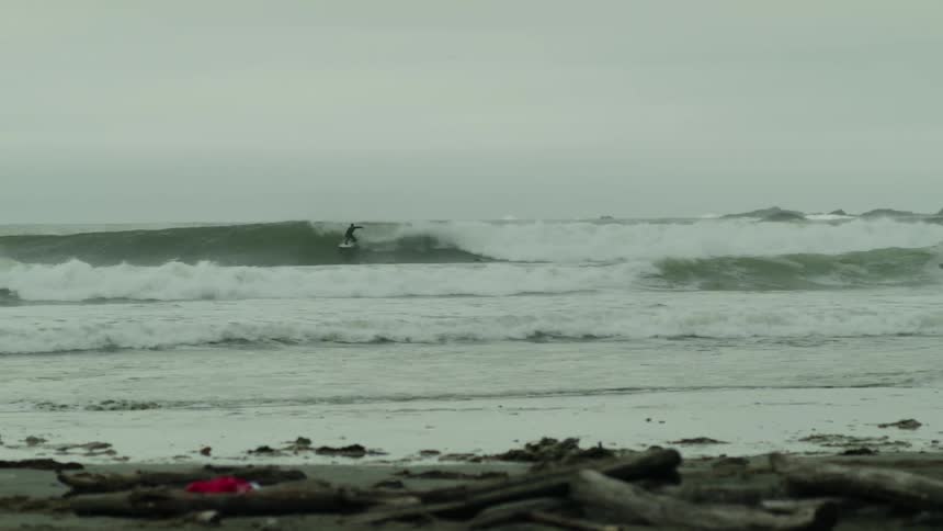 A person surfing in a choppy sea in bad weather