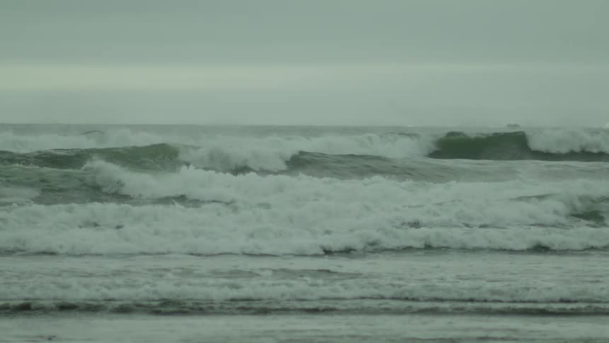 A beach with rough seas during a cloudy day