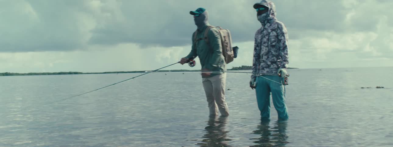 Friends fishing in the sea during sunset