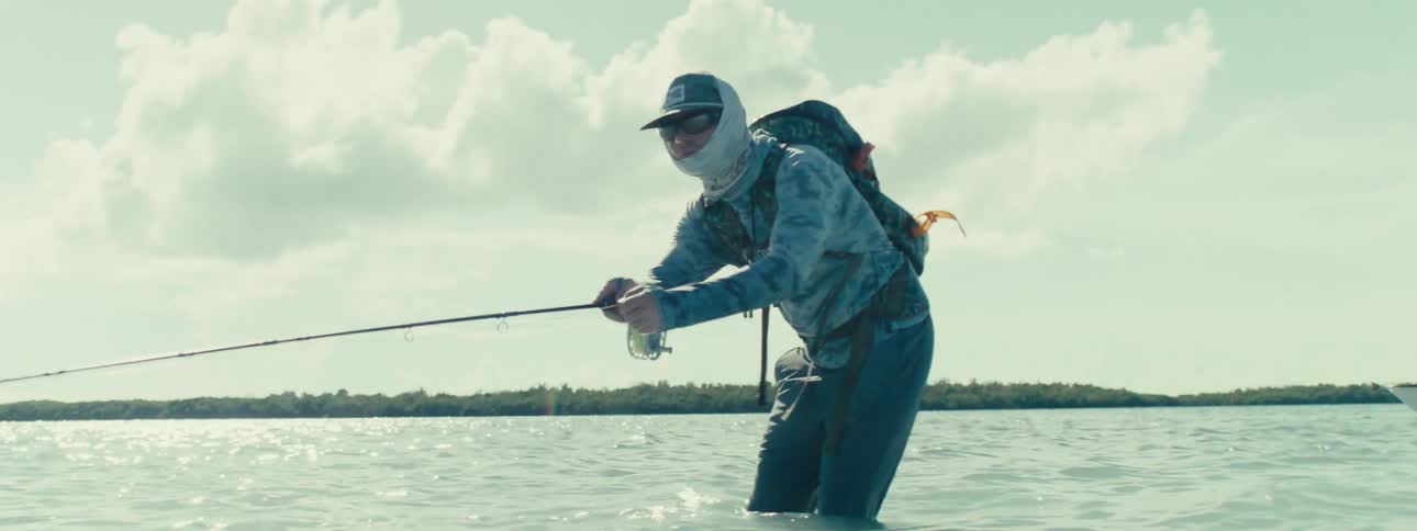 A man fishing in a sea with high tide