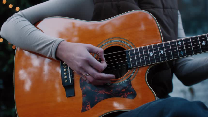 A person playing guitar outdoors
