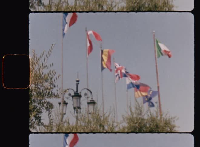 Flags of countries raised and waving in the wind on a sunny day