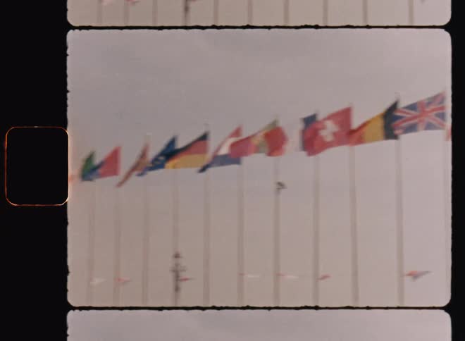 Fourteen european flags wave in the breeze against a cloudy sky