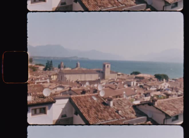 Roofs of an european town next to the ocean caught on vintage film