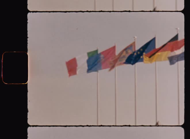 View of poles with flags of different countries in a cloudy sky
