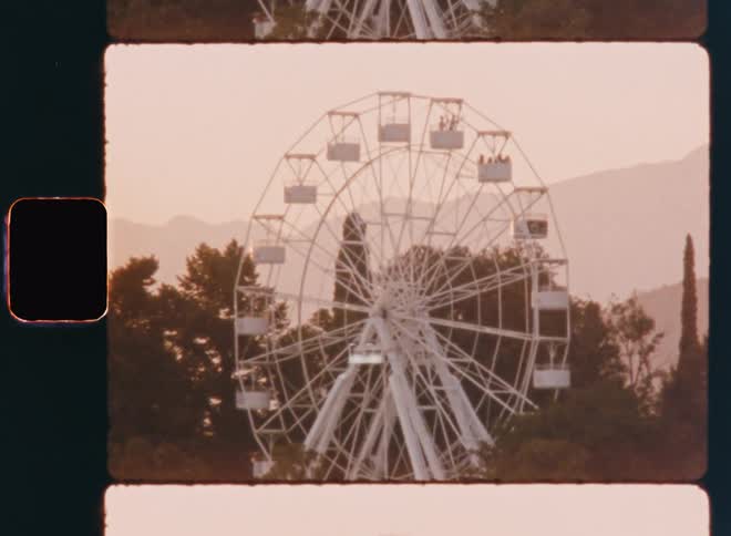 Panorama of a moving ferris wheel in a natural environment