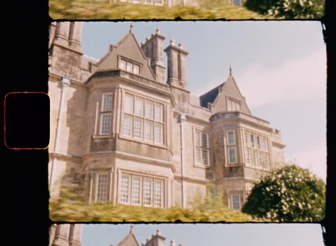 A building with ancient castle architecture with huge windows and plants in front