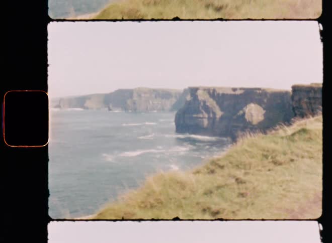 A cliff on shore with grasses on top
